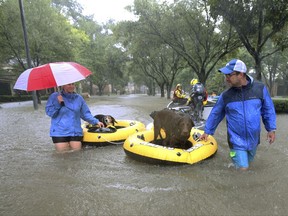 FILE - In this Aug. 28, 2017 file photo, residents and pets are evacuated from their homes as floodwaters from Tropical Storm Harvey rise in Houston. Animal Planet is airing a special Saturday night called "Surviving Harvey: Animals After the Storm." The program airs Saturday at 8 p.m. on the East and West coasts. (Godofredo A. Vasquez/Houston Chronicle via AP, File)