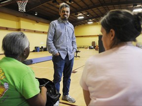 In this Thursday, Aug. 31, 2017, photo, Ayman Kabire, a volunteer at Champions Mosque with the Islamic Society of Greater Houston, talks to evacuees at a mosque that was being used as a shelter. Houston's Muslim community, an estimated 200,000 people, has opened many of its community centers and sent hundreds of volunteers to serve food and deliver donations. Some have rescued neighbors from high water. (AP Photo/Jay Reeves)