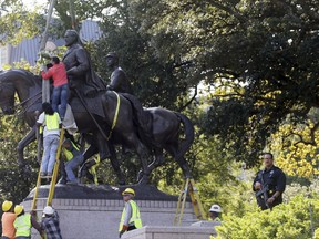 Workers prepare for the removal of a statue of Robert E. Lee at a public park in Dallas, Thursday, Sept. 14, 2017. (AP Photo/LM Otero)