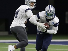 Dallas Cowboys quarterback Dak Prescott (4) hands off to teammate running back Ezekiel Elliott (21) during an NFL football practice in Frisco, Texas, Thursday, Sept. 7, 2017. (AP Photo/LM Otero)