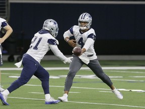 Dallas Cowboys quarterback Dak Prescott (4) hands off to teammate running back Ezekiel Elliott (21) during an NFL football practice in Frisco, Texas, Thursday, Sept. 7, 2017. (AP Photo/LM Otero)