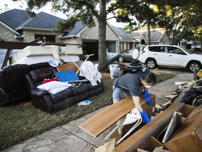 Chumming Xu looks through his flood damaged belongings in the aftermath of Hurricane Harvey on Thursday, Sept. 7, 2017, at the Canyon Gate community in Katy, Texas. (AP Photo/Matt Rourke)