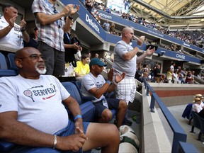 From left, Army veteran Henry Pruitt, Marine veteran Jon Atkins, and Air Force veteran Marc Spittler, all from Orlando, Fla., watch play between CoCo Vandeweghe, of the United States, and Lucie Safarova, of the Czech Republic, during the fourth round of the U.S. Open tennis tournament, Monday, Sept. 4, 2017, in New York. (AP Photo/Jason Decrow)