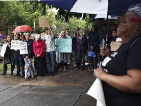 Community members and protesters from "Showing Up For Racial Justice" (SURJ) Charlottesville and Black Lives matter chant outside of the Charlottesville Circuit Court house before a hearing set to discuss the pending court case regarding the removal of Confederate statues in the city, Friday, Sept. 1, 2017 in Charlottesville, Va. The controversy over the statue sparked the Aug. 12 "Unite the Right" rally that descended into violent chaos. Charlottesville has since shrouded the monument with a black tarp as a symbol of mourning for the woman who was killed.   (Zack Wajsgras/The Daily Progress via AP)