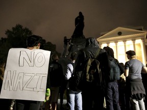 A group of protesters stand in front of the Rotunda at the University of Virginia for the one month anniversary of the "Unite the Right" rally in Charlottesville, Va., Tuesday, Sept. 12, 2017. The group circled around the statue of Thomas Jefferson before covering it with black tarp and listing demands for the university. (Zack Wajsgras/The Daily Progress via AP)