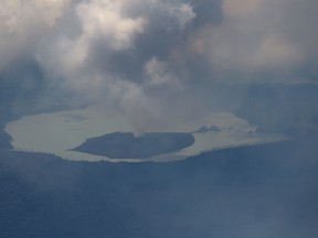 Columns of smoke, ash and volcanic rocks billowing from the crater of an erupting volcano on Vanuatu's Ambae Island