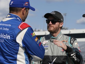 Dale Earnhardt Jr., right, talks with Elliott Sadler prior to qualifying for the Xfinity Series auto race at the Richmond International Raceway in Richmond, Va., Friday, Sept. 8, 2017. (AP Photo/Steve Helber)