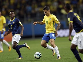 Brazil's Philippe Coutinho, center, runs with the ball as Ecuador's Juan Cazeres, left, looks on during a 2018 World Cup qualifying soccer match in Porto Alegre, Brazil, Thursday, Aug. 31, 2017. (AP Photo/Andre Penner)
