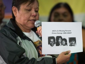 Marlene Jack holds photos of her missing sister, Doreen Jack, Doreen's husband, Ronald, and the couple's two sons, Ryan and Russell, who disappeared from Prince George in 1989, while testifying during hearings at the National Inquiry into Missing and Murdered Indigenous Women in Smithers, B.C., on Sept. 27, 2017.