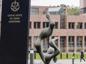 FILE - In this Oct. 5, 2015 file photo, a man walks by the European Court of Justice in Luxembourg. The European Court of Justice on Wednesday, Sept. 6, 2017 rejected efforts by Hungary and Slovakia to stay out of a European Union scheme to relocate refugees. (AP Photo/Geert Vanden Wijngaert, File)