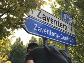 A man walks under a sign, in the center of Zaventem, Belgium, Wednesday, Sept. 27, 2017. Belgian police have arrested a person based on a Spanish arrest warrant, that national media say is the leader of an "Islamist terrorist cell."  (AP Photo/Geert Vanden Wijngaert)