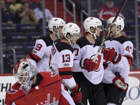 New Jersey Devils center Nico Hischier (13), of Switzerland, celebrates his goal with John Quenneville (47), Marcus Johansson, second from right, and Drew Stafford (18) as Washington Capitals goalie Braden Holtby (70) looks back at the goal during the first period of an NHL preseason hockey game, Wednesday, Sept. 27, 2017, in Washington. (AP Photo/Nick Wass)
