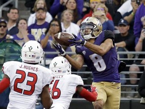 Washington's Dante Pettis (8) catches a touchdown pass in the end zone as a pair of Fresno State defenders move in in the first half of an NCAA college football game, Saturday, Sept. 16, 2017, in Seattle. (AP Photo/Elaine Thompson)