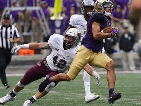 Washington's Dante Pettis returns a punt 67 yards for a touchdown as Montana linebacker Josh Buss reaches for him, during the second quarter of an NCAA college football game Saturday, Sept. 9, 2017, in Seattle. (Steve Ringman/The Seattle Times via AP)