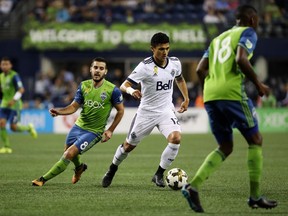 Seattle Sounders' Victor Rodriguez (8) guards Vancouver Whitecaps' Fredy Montero (12) during the first half of an MLS soccer match in Seattle on Wednesday, Sept. 27, 2017. (Erika Schultz/The Seattle Times via AP)