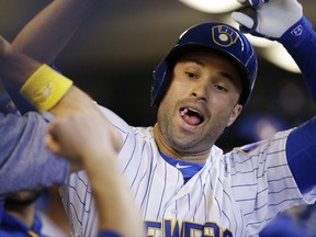 Milwaukee Brewers' Neil Walker celebrates in the dugout after his home run against the Washington Nationals during the first inning of a baseball game Friday, Sept. 1, 2017, in Milwaukee. (AP Photo/Jeffrey Phelps)