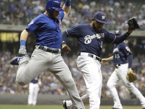 Chicago Cubs' Ian Happ is safe at first as he beats Milwaukee Brewers' Jeremy Jeffress to the bag during the ninth inning of a baseball game Thursday, Sept. 21, 2017, in Milwaukee. (AP Photo/Morry Gash)