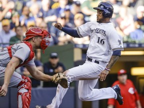 Milwaukee Brewers' Domingo Santana, right, begins his slide to beat the throw to Cincinnati Reds' Stuart Turner, left, during the fourth inning of a baseball game Thursday, Sept. 28, 2017, in Milwaukee. (AP Photo/Tom Lynn)