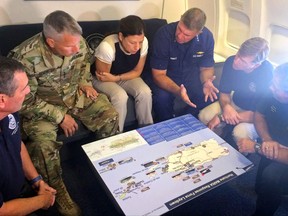 Acting Homeland Secretary Elaine Duke, center, is briefed on the Hurricane Maria response during a flight to Puerto Rico on Friday, Sept. 29, 2017. President Donald Trump on Thursday cleared the way for more supplies to head to Puerto Rico by waiving restrictions on foreign ships delivering cargo to the island.  (AP Photo/Luis Alonso Lugo)