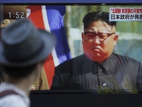 FILE - In this Sept. 3, 2017, file photo, a man watches a TV news program on a public screen showing an image of North Korean leader Kim Jong Un while reporting North Korea's possible nuclear test in Tokyo. The top commander of U.S. nuclear forces says he assumes the Sept. 3 nuclear test by North Korea was a hydrogen bomb. Air Force Gen. John E. Hyton, commander of Strategic Command, told reporters that while he was not in position to confirm it, he assumes from the size of the underground explosion and other factors that it was a hydrogen bomb, which is a leap beyond the fission, or atomic, bombs North Korea has previously tested.(AP Photo/Eugene Hoshiko)