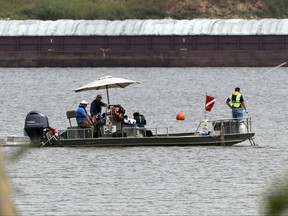 In this Sept. 13, 2017 photo, a boat with a dive flag is shown at San Jacinto River Waste Pits near the Interstate 10 bridge over the river in Channelview, Texas. The Environmental Protection Agency says an unknown amount of a dangerous chemical linked to birth defects and cancer may have washed downriver from a Houston-area Superfund site during the flooding from Hurricane Harvey.  (AP Photo/David J. Phillip)