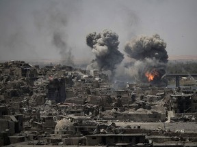 In this July 11, 2017 photo, airstrikes target Islamic State positions on the edge of the Old City a day after Iraq's prime minister declared "total victory" in Mosul, Iraq.  The U.S. military declassifies 81 locations of unexploded, coalition bombs dropped in Mosul in new effort to help aid groups and contractors clear explosives from Iraq's war-scarred cities.  (AP Photo/Felipe Dana)