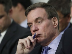 FILE - In this June 13, 2017, file photo, Senate Intelligence Committee Vice Chairman Mark Warner, D-Va., listens during a committee hearing on Capitol Hill in Washington. Warner said an overhaul of the security clearance process is long overdue, particularly if the U.S. government is going to continue to attract top-notch workers and recent graduates, and not hamper transitions of mid-career intelligence professionals from agency to agency. (AP Photo/J. Scott Applewhite)