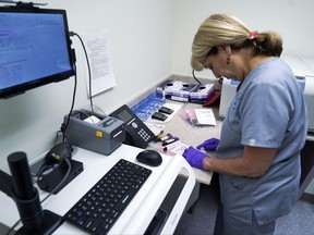 In this Aug. 7, 2017, photo, Stephanie Richurk, a nurse at the University of Pittsburgh Medical Center, sorts blood samples collected from participants in the "All of Us" research program in Pittsburgh. The "All of Us" research program is run by the National Institutes of Health and plans to track the health of at least 1 million volunteers by 2019. By doing so, researchers hope to learn how to better tailor treatments and preventative care to people's genes, environments, and lifestyle. The University of Pittsburgh is running a pilot program with some of the first enrollees in the study. (AP Photo/Dake Kang)