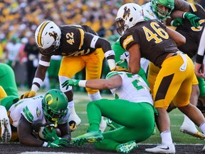 CORRECTS DATE Oregon running back Royce Freeman (21) places the ball in the end zone for a touchdown during the first half of an NCAA college football game against Wyoming in Laramie, Wyo., Saturday, Sept. 16, 2017. (AP Photo/Shannon Broderick)