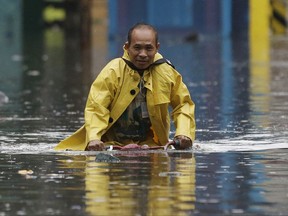 A man pedals his bicycle along a flooded street in Manila, Philippines on Tuesday, Sept. 12, 2017. Classes in schools and work in government offices have been suspended in the capital and nearby provinces as heavy rains pour causing floods in low-lying areas due to Tropical Depresion "Maring". (AP Photo/Aaron Favila)