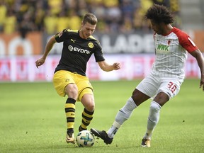 Augsburg's Caiuby, right, and Dortmund's Lukasz Piszczek  challenge for the ball during the German Bundesliga soccer match between FC Augsburg and Borussia Dortmund in Augsburg, southern Germany, Saturday. Sept. 30, 2017.  (Andreas Gebert/dpa via AP)
