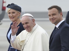 File - In this file photo taken July 27, 2016, Pope Francis, center, greets faithful as he walks with Polish President Andrzej Duda, right, and First Lady Agata Kornhauser-Duda after arrival at the military airport in Krakow. Poland's influential Roman Catholic Church is recently critical of the government policies. (AP Photo/Alik Keplicz)