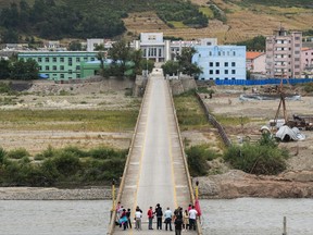 In this Sunday, Sept. 10, 2017, photo, Chinese tourists stand watch on Tumen bridge linking China and North Korea, as seen from Yanbian, Jilin province. U.S. Secretary of State Rex Tillerson on Friday, Sept. 15, 2017, calling on all nations to take new measures against Kim Jong Un's regime after North Korea's latest missile launch. (AP Photo)