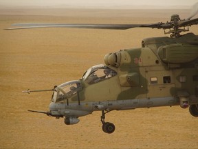 FILE - In this Friday, Sept. 15, 2017 file photo, Russian military helicopter flies over a desert in Deir es-Zor province, Syria. Russian special forces are helping Syrian government troops fight Islamic State militants in the battle underway for the strategic city of Deir el-Zour in eastern Syria, the defense ministry in Moscow said on Thursday, Sept. 21, 2017. The deployment comes amid rising concerns of a direct confrontation on the ground between Russian-backed forces on one side and the U.S.-supported Kurdish-led Syrian forces on the other. (AP Photo, File)
