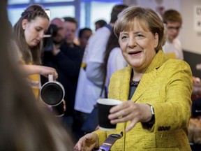 German chancellor Angela Merkel drinks a cup of coffee with election campaign workers in Berlin, Saturday, Sept. 23, 2017 ahead of Germany's election.