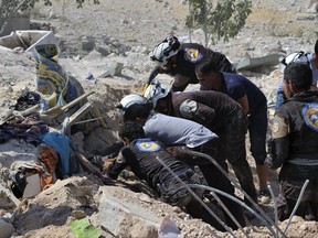 This photo provided by the Syrian Civil Defense White Helmets, which has been authenticated based on its contents and other AP reporting, shows Civil Defense workers searching through the rubble after airstrikes hit in Khan Sheikhoun, in the northern province of Idlib, Syria.