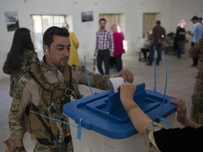 A Kurdish security guard casts his vote for independence in the city of Kirkuk, Monday Sept. 25, 2017. Iraq's Kurdish region vote in a referendum on whether to secede from Iraq. (AP Photo/Bram Janssen)