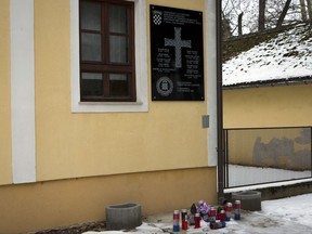 In this Jan. 26, 2017 photo, the plaque bearing WWII pro-Nazi regime salute "Za Dom Spremni" (For Homeland Ready) commemorating deaths of Croatian troops killed during 1990's conflict is on a wall in Jasenovac, Central Croatia. Croatian authorities have removed the plaque which was placed last year near the site of a notorious wartime concentration camp where tens of thousands had perished. (AP Photo/Darko Bandic)