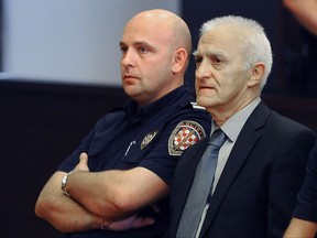 In this Tuesday, Sept. 20, 2016 file photo, Dragan Vasiljkovic, right, a former Serb paramilitary commander, sits next to a guard in a courtroom at the beginning of his trial in Split, Croatia. The municipal court has sentenced Vasiljkovic to 15 years in prison for war crimes in the 1990s Tuesday, Sept. 26, 2017. In the verdict it said that Vasiljkovic, also known as Captain Dragan and Daniel Snedden, is guilty of the killings and torture of imprisoned civilians and Croatian troops while he was a rebel Serb commander during the 1991-95 war in Croatia. (AP Photo, FILE)