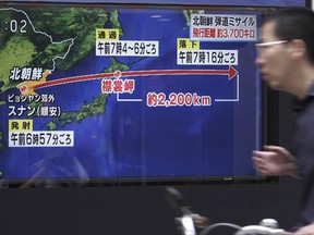 A man rides a bicycle past a public TV screen broadcasting news of North Korea's launch of missile, in Tokyo, Friday, Sept. 15, 2017. North Korea fired an intermediate-range missile over Japan into the northern Pacific Ocean on Friday, U.S. and South Korean militaries said, its longest-ever such flight and a clear message of defiance to its rivals. (AP Photo/Eugene Hoshiko)