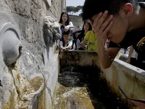 In this Aug. 9, 2017 file photo tourists refresh themselves at a fountain in Rome.  A relentless heat wave that gripped parts of Europe has sent temperatures soaring to record highs for several days. Researchers say the likelihood of scorching summer temperatures in southern Europe is increasing because of man-made climate change. Hotter-than-usual temperatures in the Mediterranean region - including an August heatwave in Italy and the Balkans dubbed 'Lucifer' - resulted in higher hospital admissions, numerous forest fires and widespread economic losses this summer.  (AP Photo/Gregorio Borgia,file)