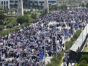 Local residents walk to attend a mass protest in Chechnya's provincial capital Grozny, Russia, Monday, Sept. 4, 2017. Tens of thousands of people have taken to the streets in Russia's predominantly Muslim Chechnya to protest what the Chechen leader called "genocide of Muslims" in Myanmar. (AP Photo/Musa Sadulayev)