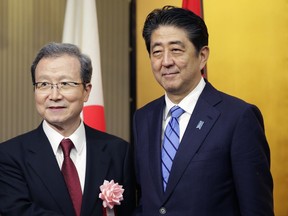 Japanese Prime Minister Shinzo Abe, right, poses with Chinese Ambassador to Japan Cheng Yonghua during a reception of China's National Foundation day and 45th-anniversary of Japan-China bilateral relations at a hotel in Tokyo, Thursday, Sept. 28, 2017. (AP Photo/Shizuo Kambayashi)