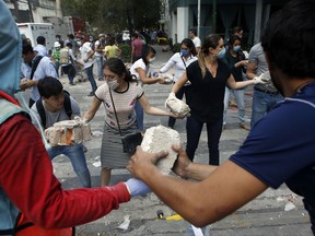 Volunteers pick up the rubble from a building that collapsed during an earthquake in the Condesa neighborhood of Mexico City, Tuesday, Sept. 19, 2017. A powerful earthquake jolted central Mexico on Tuesday, causing buildings to sway sickeningly in the capital on the anniversary of a 1985 quake that did major damage. (AP Photo/Rebecca Blackwell)