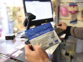 FILE - In this  July 19, 2017 file photo, a pharmacist register a bag of legal marijuana as he sells it to a customer, at a pharmacy in Montevideo, Uruguay. The country is changing its marijuana selling system because banks were making it difficult for pharmacies to sell pot as had been planned. A government official said Wednesday Sept. 13 2017, that Uruguay will set up shops to sell pot for cash and avoid the problems faced by pharmacies. (AP Photo/Matilde Campodonico, File)