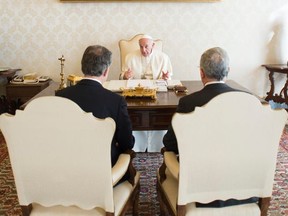 FILE - In this Dec. 16, 2016 file photo, Pope Francis talks to Colombian President Juan Manuel Santos, left, and former President Alvaro Uribe, right, during a meeting at the Vatican. Francis has been one of the chief advocates for peace in Colombia, a deeply Catholic country, urging leaders for and against the agreement to settle their differences.  (L'Osservatore Romano/Pool photo via AP, File)