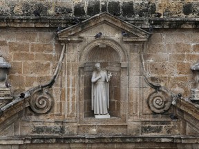 This Aug. 30, 2017 photo shows a statue depicting the 17th-century missionary St. Peter Claver recessed in an alcove on the facade of the church bearing his name, in Cartagena, Colombia. On the final day of his visit to Colombia, Pope Francis will honor the fellow Jesuit, who declared himself the "slave of the slaves forever."  (AP Photo/Pedro Mendoza)