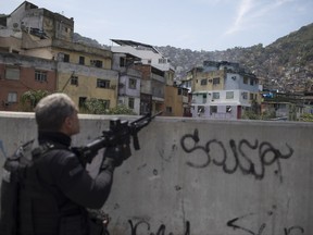 A police officer takes a position during an operation in the Rocinha slum in Rio de Janeiro, Brazil, Friday, Sept. 22, 2017. Shootouts have erupted in several areas of Rio de Janeiro, prompting Brazilian authorities to shut roads and close schools. (AP Photo/Leo Correa)