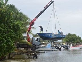 Men remove boats from the water ahead of Hurricane Maria in the Galbas area of Sainte-Anne on the French Caribbean island of Guadeloupe, early Monday, Sept. 18, 2017. Hurricane Maria grew into a Category 3 storm on Monday as it barreled toward a potentially devastating collision with islands in the eastern Caribbean. (AP Photo/Dominique Chomereau-Lamotte)