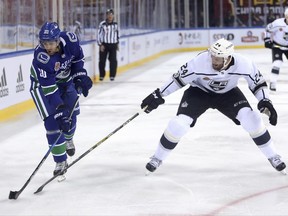 The Vancouver Canucks' Brandon Sutter, left, takes a shot on goal past the Los Angeles Kings' Derek Forbort during the first period of an NHL China exhibition game at the Cadillac Arena in Beijing, Saturday, Sept. 23, 2017. (AP Photo/Mark Schiefelbein)